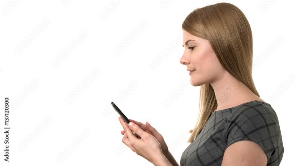 Beautiful businesswoman in grey dress working on her smartphone. Isolated white background. Beautiful businesswoman in grey dress working on her smartphone. Isolated white background.