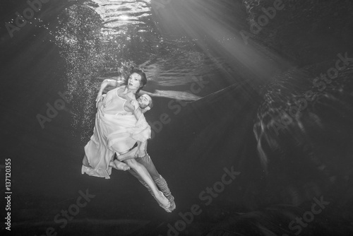 Young couple of ballet dancers dancing unerwater