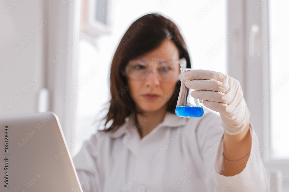 Picture of beautiful lab worker holding up test tube Picture of beautiful lab worker holding up test tube