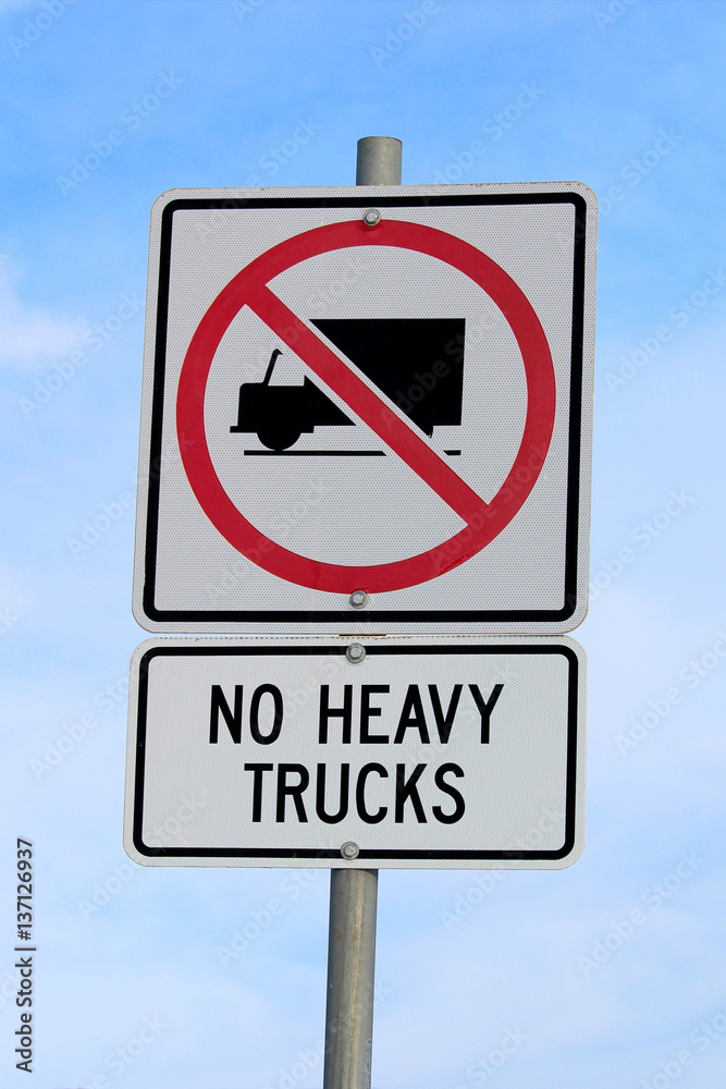 No Heavy Trucks Sign against Cloudy Blue Sky Background No Heavy Trucks Sign against Cloudy Blue Sky Background