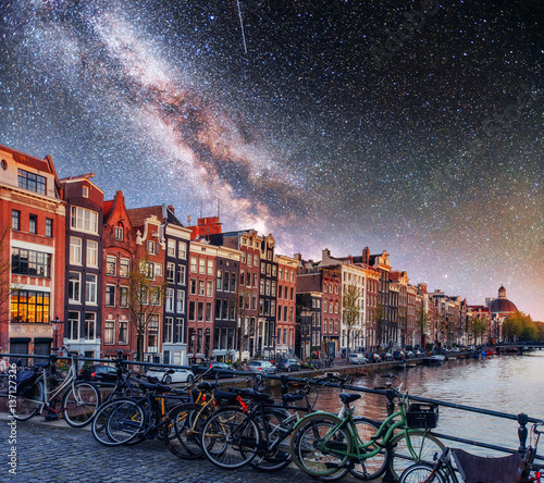 Starry sky over Amsterdam. Street bikes on the bridge