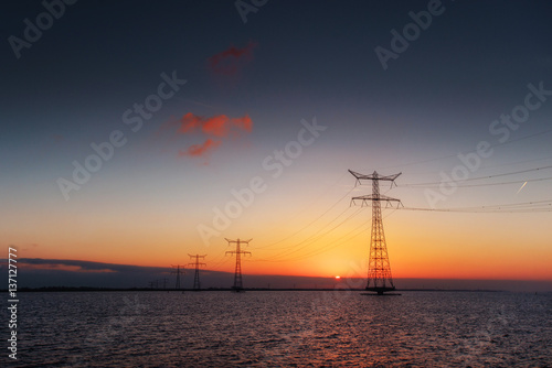 electric line above water during a fantastic sunset © standret