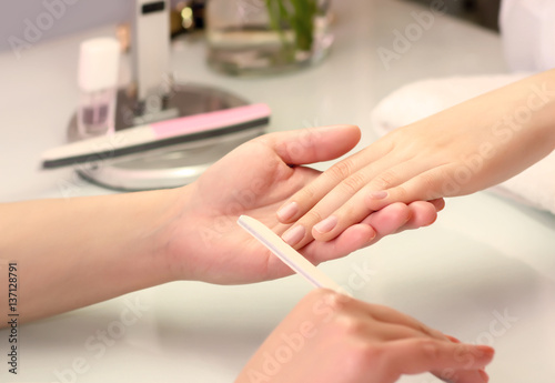 Woman hands in a nail salon receiving a manicure procedure. SPA manicure.