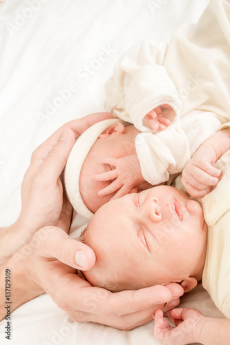 newborn twin babies in father's hands