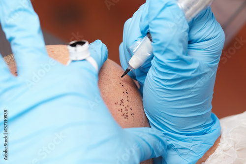 professional tattooist making permanent make up tricopigmentation photo