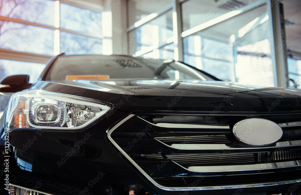 The headlights and the hood of a black sports car