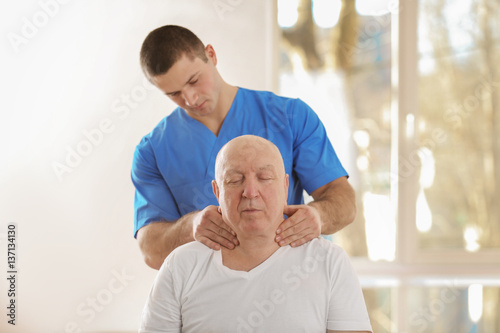 Physiotherapist working with elderly patient in clinic