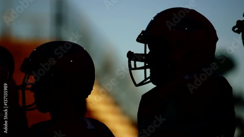 Silhouetted football players close up