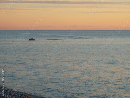 Small boat in the sea, sunset sky