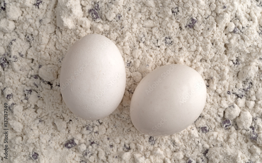 Top view of two eggs on blueberry muffin mix. Top view of two eggs on blueberry muffin mix.