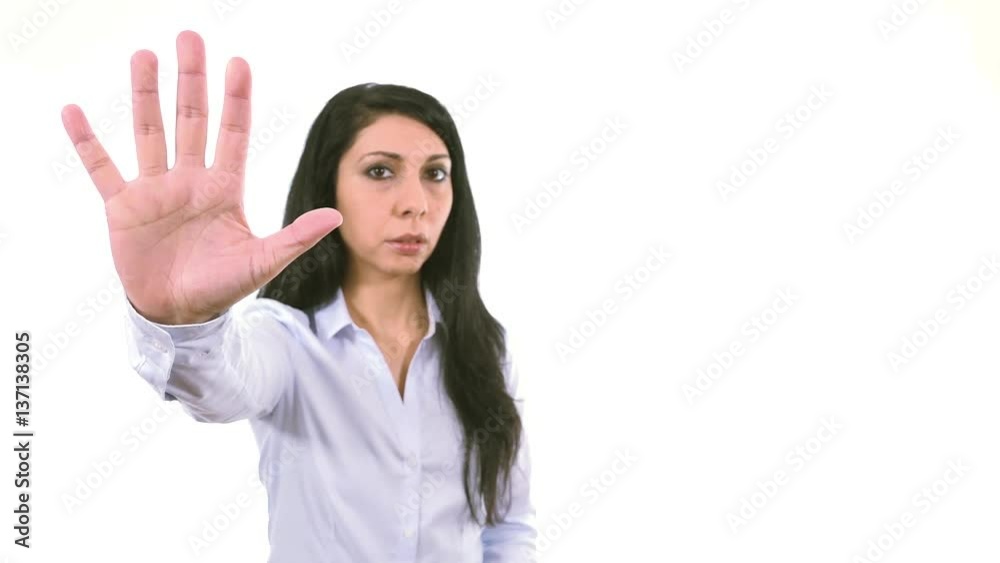 Serious woman rising hand showing stop expression indoor white background medium close up, soft focused businesswoman Serious woman rising hand showing stop expression indoor white background medium close up, soft focused businesswoman