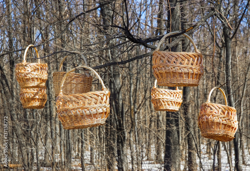 Trade of Handicrafts in the street in the spring. Wicker baskets hung on the branches of trees photo