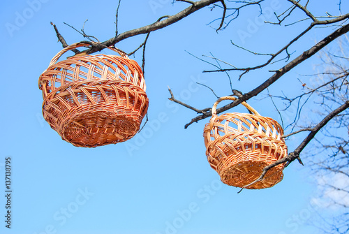 Trade of Handicrafts in the street in the spring. Wicker baskets hung on the branches of trees photo