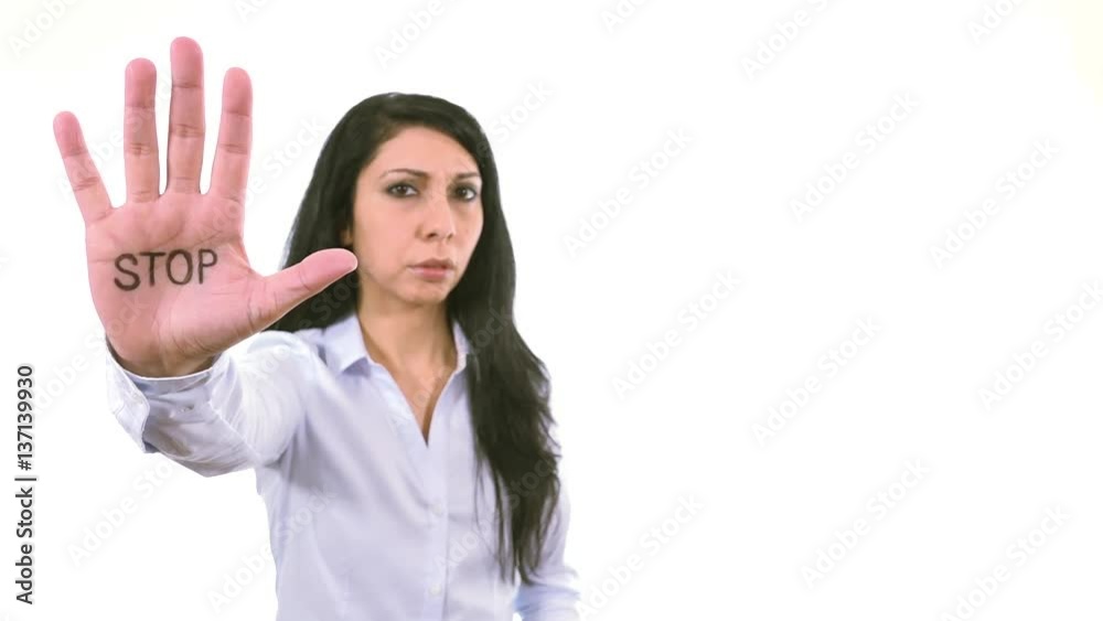 Serious woman rising hand showing word STOP on palm disapproval expression indoor white background medium close up, soft focused businesswoman Serious woman rising hand showing word STOP on palm disapproval expression indoor white background medium close up, soft focused businesswoman