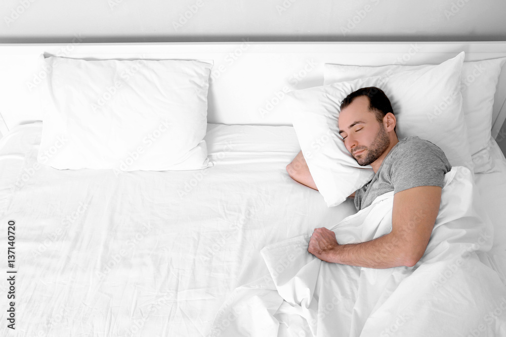 Tired young man sleeping in bed Tired young man sleeping in bed