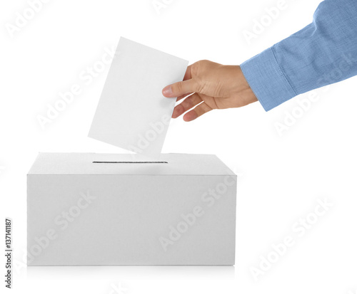 Male hand putting voting ballot into the box on white background