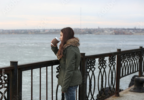 Depressed young woman drinking coffee on pier © Africa Studio