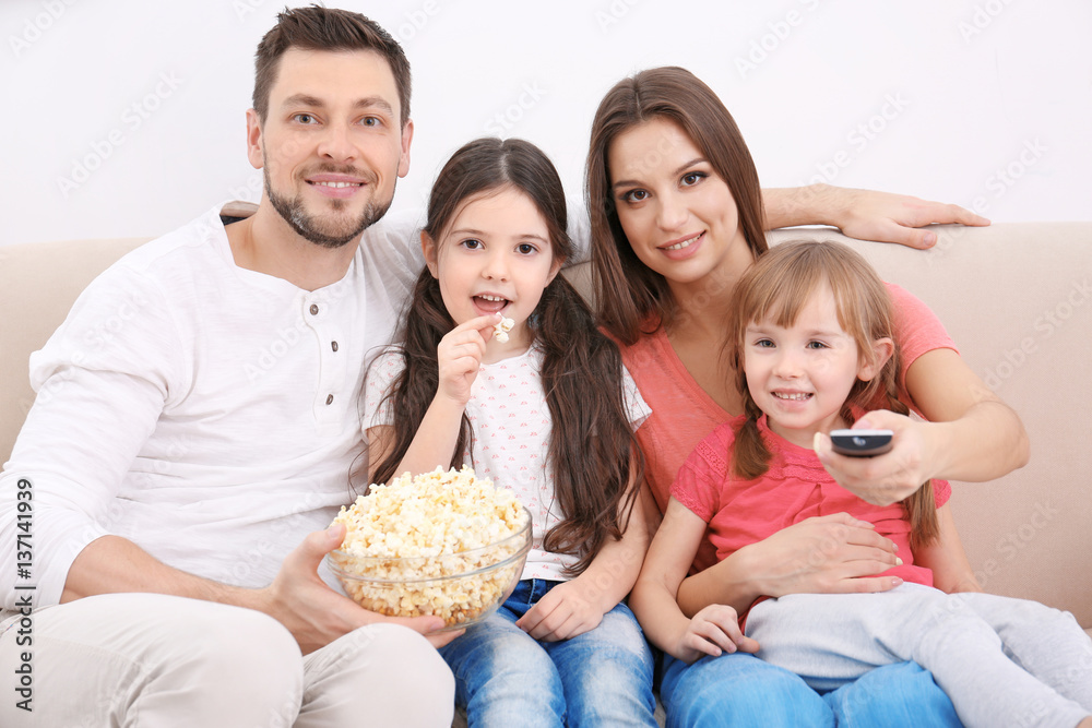 Happy family watching TV on sofa at home Happy family watching TV on sofa at home
