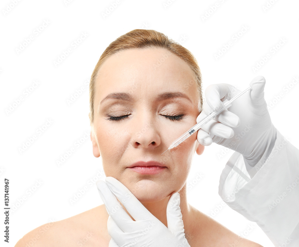 Plastic surgery concept. Mature woman receiving injection on white background