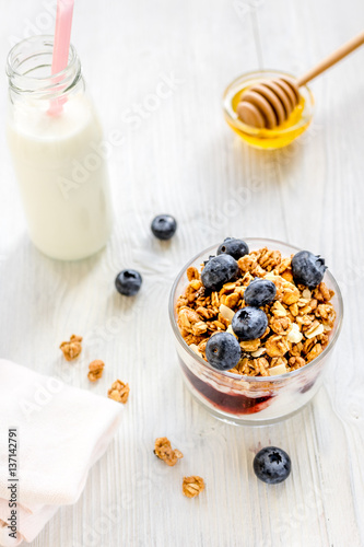 Fitness breakfast with granola, milk and honey on white background