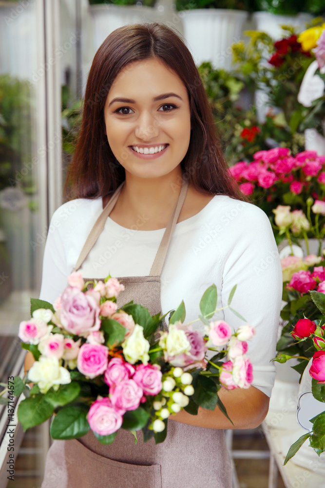 Pretty young florist with bouquet in flower shop Pretty young florist with bouquet in flower shop