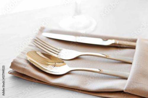 Fork, spoon and knife on linen napkin
