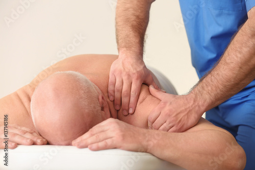 Physiotherapist working with elderly patient in clinic