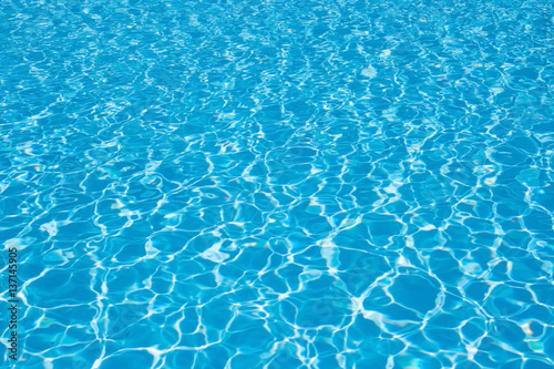 Blue pool water background, wave. Clean and bright water in swimming pool.