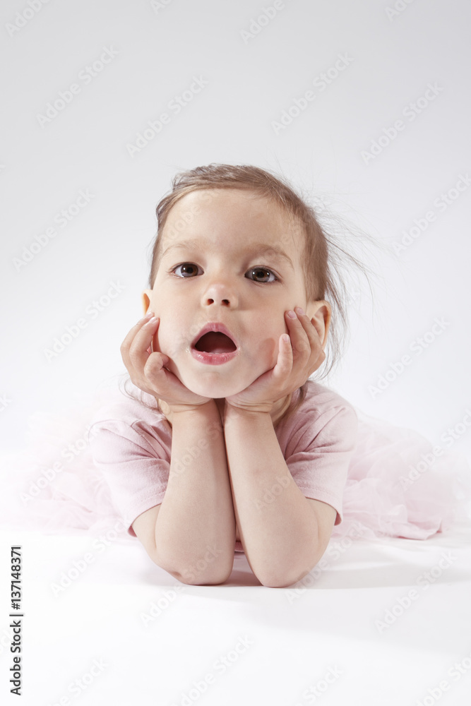 Portrait of Yawning Little Caucasian Blond Child Posing in Pink Dress Against White Background. Portrait of Yawning Little Caucasian Blond Child Posing in Pink Dress Against White Background.