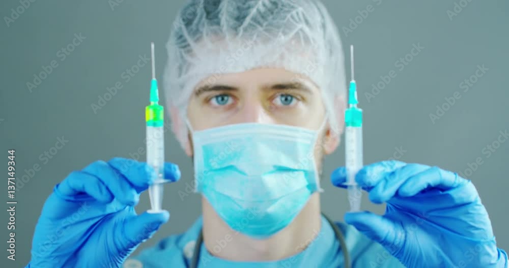 A doctor or scientist in laboratory holding a syringe with liquid vaccines for children or older adults, or cure animal diseases. Concept:diseases,medical care,science, anesthesia,euthanasia,diabetes. A doctor or scientist in laboratory holding a syringe with liquid vaccines for children or older adults, or cure animal diseases. Concept:diseases,medical care,science, anesthesia,euthanasia,diabetes.