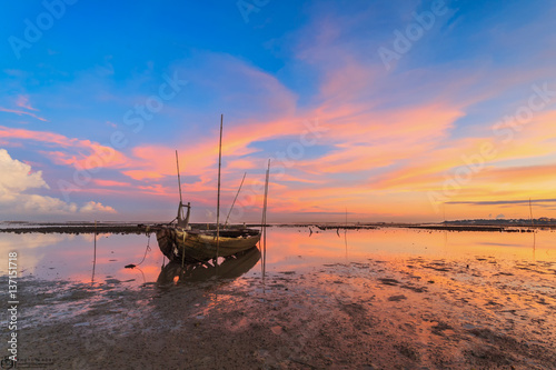 Wrecked fishing boat at sea with sunset
