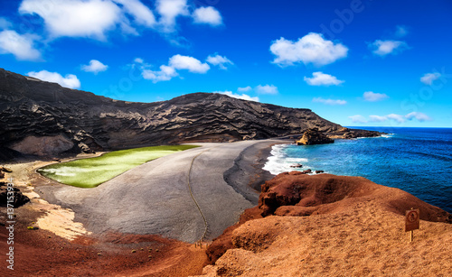 View into a volcanic crater with its green lake near El Golfo, Lanzarote island, Spain photo