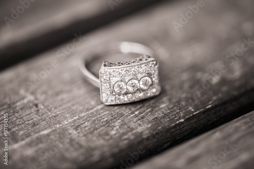 An engagement and wedding ring placed on a wooden surface