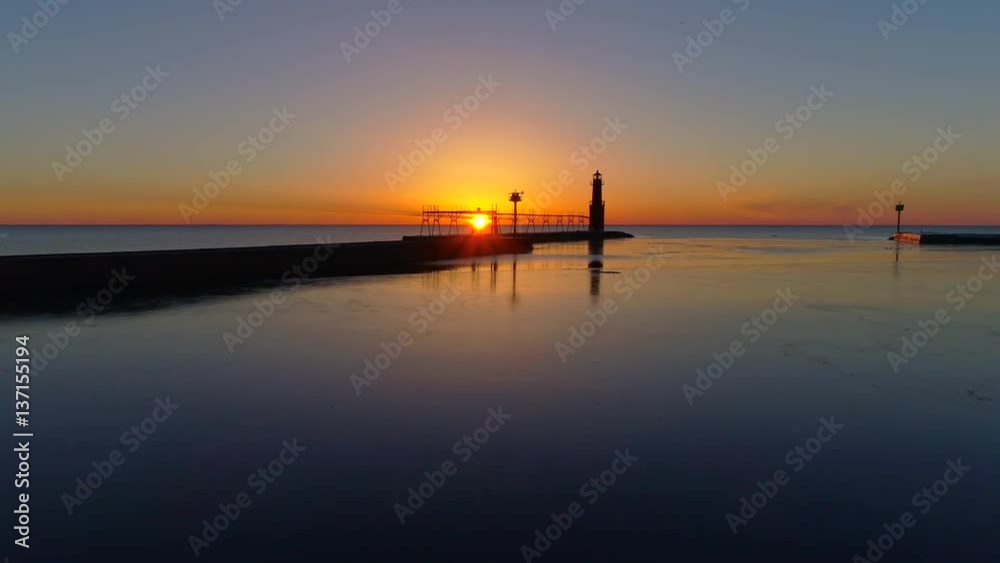 Scenic aerial flyby of Lake Michigan lighthouse, harbor at sunrise.
Scenic aerial flyby of Lake Michigan lighthouse, harbor at sunrise.