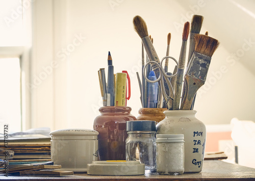 Collection of drawing instruments, paint brushess, pencils and pots
