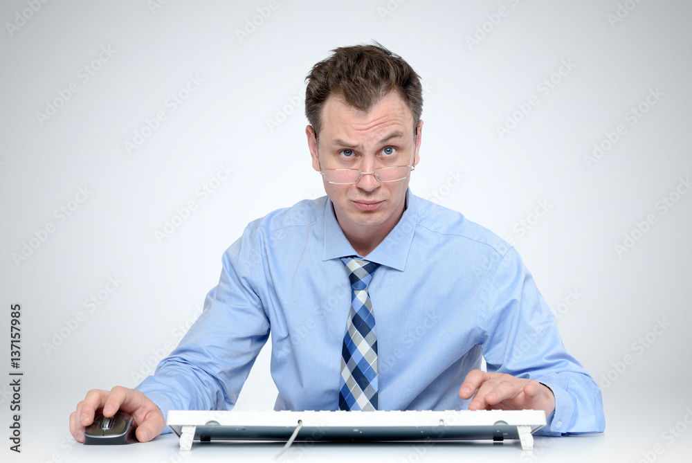 Man with glasses and tie at the keyboard in front of computer Man with glasses and tie at the keyboard in front of computer