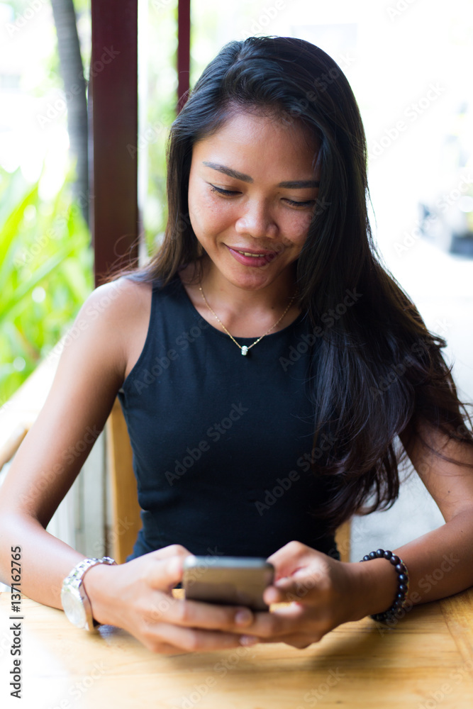 Young girl at a cafe using a smart phone 