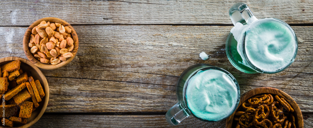 Green beer in mugs on rustic wood background Green beer in mugs on rustic wood background