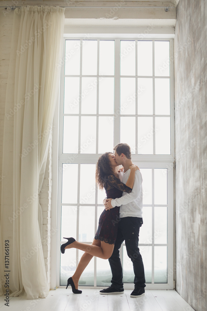 beautiful young couple having a conversation while looking at each other over a window background beautiful young couple having a conversation while looking at each other over a window background