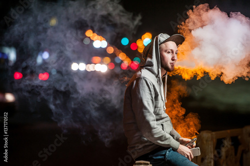handsome young man smoking electronic cigarette