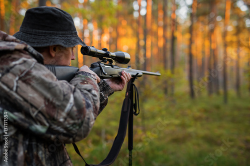 Hunter aiming with rifle