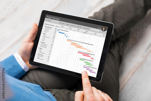 Man using project management app on tablet computer photo