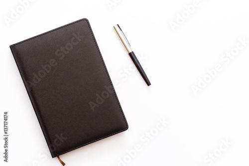 black diary and pen on a white background