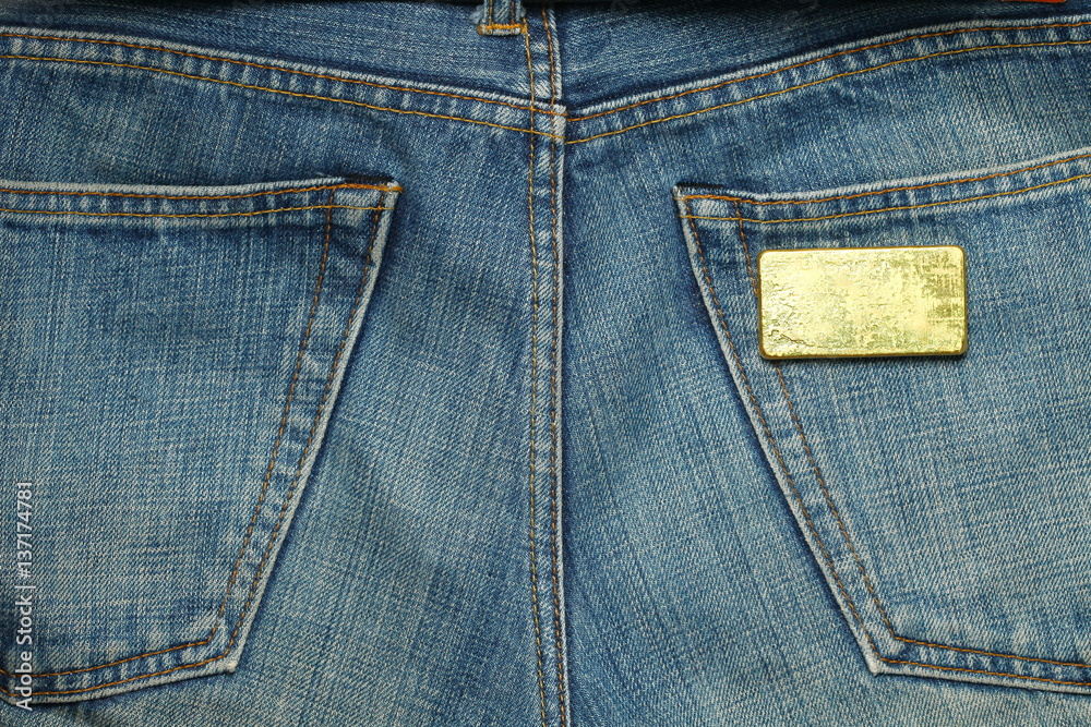 The gold bar put in the jean pocket background represent gold and business finance concept related idea. The gold bar put in the jean pocket background represent gold and business finance concept related idea.