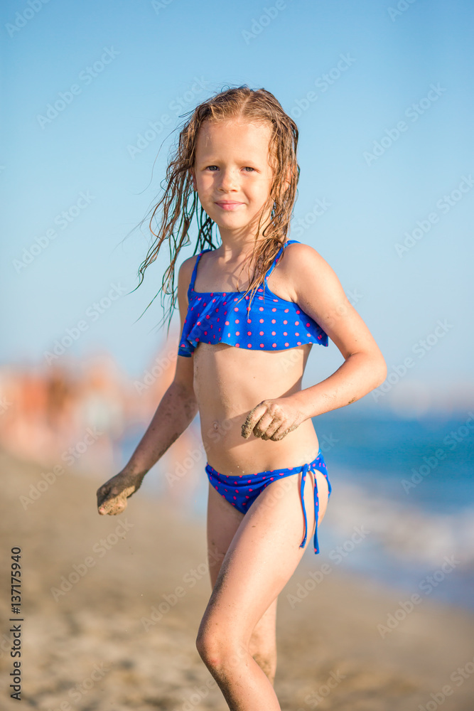 Adorable little girl have fun at tropical beach during vacation Adorable little girl have fun at tropical beach during vacation