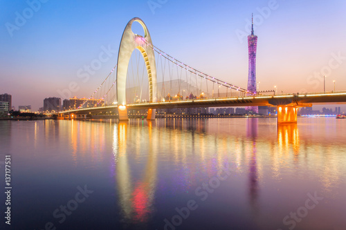 Light show in sunset time at modern bridge in Zhujiang river and modern building of financial district in guangzhou city, China
