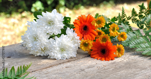 bouquet de fleurs blanches et oranges sur planche en bois 