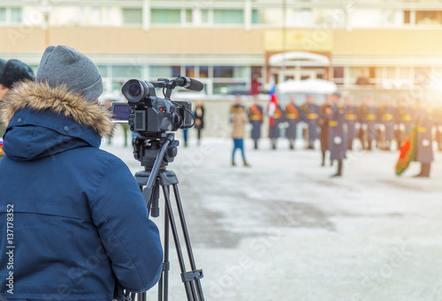 Cameraman shooting a military parade in the winter