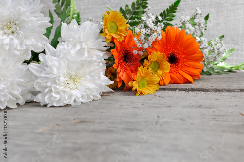 bouquet de fleurs blanches et oranges sur fond bois