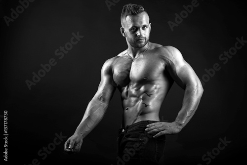 Young attractive sexy male fitness model demonstrates his muscular body © zoya